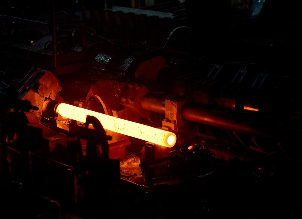 Tubo de aço super aquecido, em máquina industrial, demonstrando a produção de tubo de aço Tubo de aço super aquecido, em máquina industrial, demonstrando a produção de tubo de aço